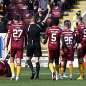 Referee David Dickinson shows a yellow card to Rangers' Leon King for his foul on Motherwell's Stuart McKinstry.