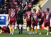 Referee David Dickinson shows a yellow card to Rangers' Leon King for his foul on Motherwell's Stuart McKinstry.