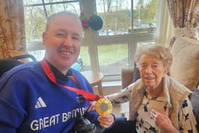 Stephen McGuire shows resident May Wilson his gold medal