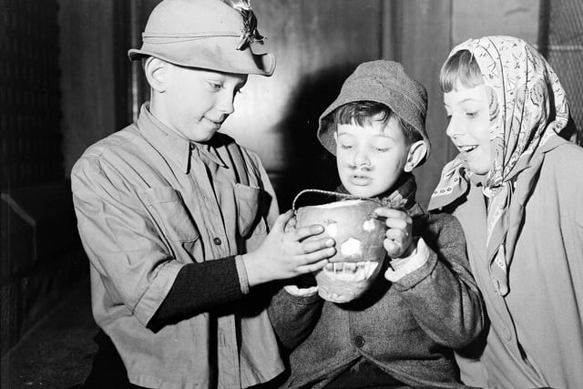 Before pumpkins, we used to carve turnips. Here young guisers warm their hands over their turnip lanterns at Halloween 1956.