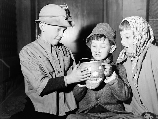 Before pumpkins, we used to carve turnips. Here young guisers warm their hands over their turnip lanterns at Halloween 1956.