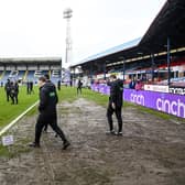 Officials walk onto the pitch to conduct an inspection of Dens Park - the Dundee v Rangers match was eventually called off.