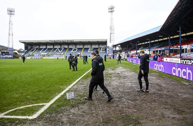 Officials walk onto the pitch to conduct an inspection of Dens Park - the Dundee v Rangers match was eventually called off.