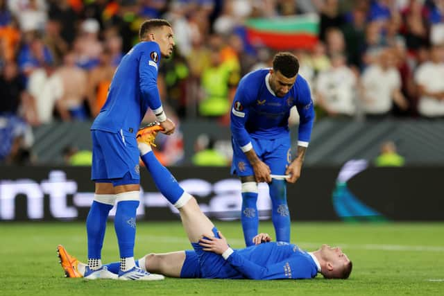 Rangers captain James Tavernier helps out John Lundstram with cramp during the Europa League final match against Eintracht Frankfurt. (Photo by Alex Pantling/Getty Images)