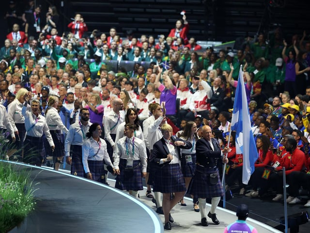 Flagbearer Alex Marshall of Team Scotland and King's Baton Bearer Sarah Adlington of Team Scotland lead their team