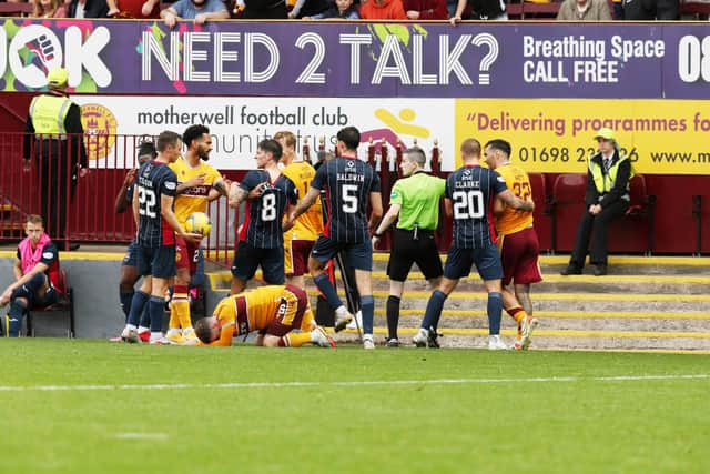 Players from both sides clash as Slattery lies on the deck