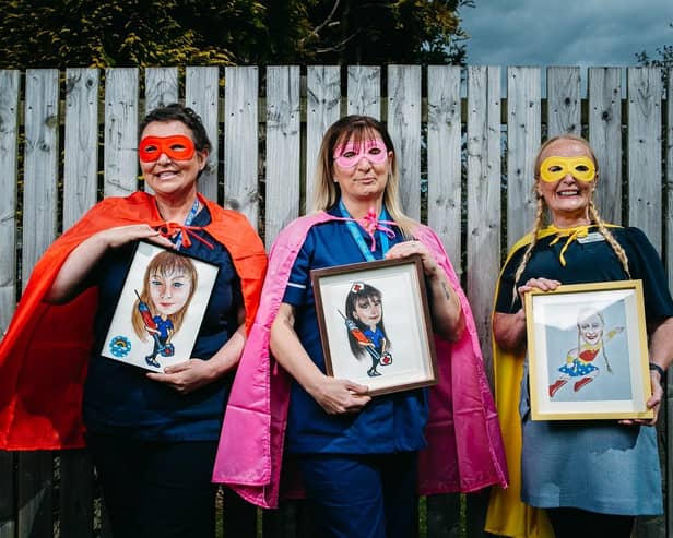 7/5/2021. FREE TO USE PICS. Pics of care home nurse Lynn Bell, who has done cartoon "superhero" paintings of all her colleagues at Parksprings Care Home in Motherwell.Pic shows L-R: Linda Webb, Michelle Carrigan, Rosie Brennan. 