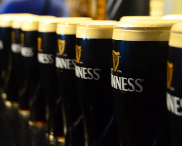 Pints of Guinness sit on top of a bar ready to be collected for St. Patrick's Day.