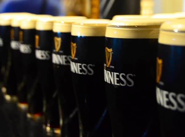 Pints of Guinness sit on top of a bar ready to be collected for St. Patrick's Day.
