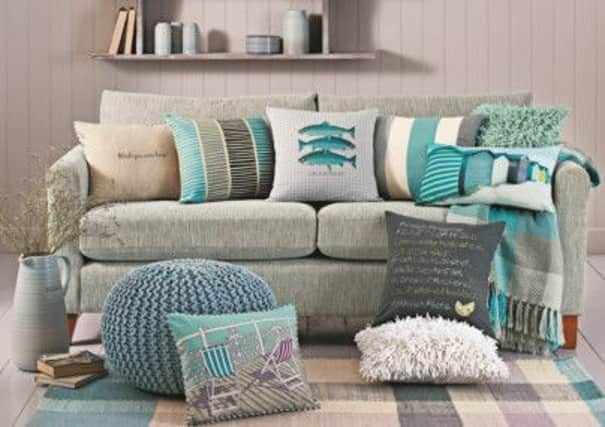 Next's collection of coastal style accessories including beach hut cushion, £12; reversible deckchair cushion, £12; reversible Catch of the Day cushion, all from Next. PA Photo/Handout.