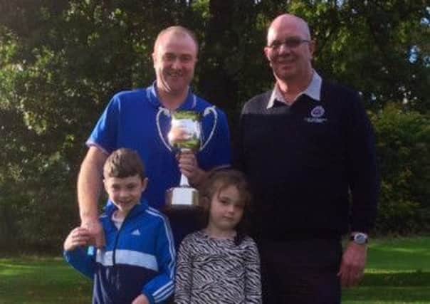 This years Club Champion, Simon Thomson, proudly watched by his two children, Josh and Grace, receiving the Dawson Trophy from Club Captain Alex Burns.