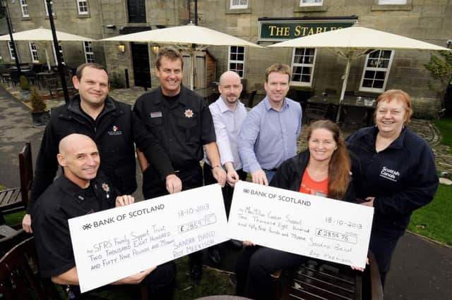 The cycling team presenting cheques to the charities