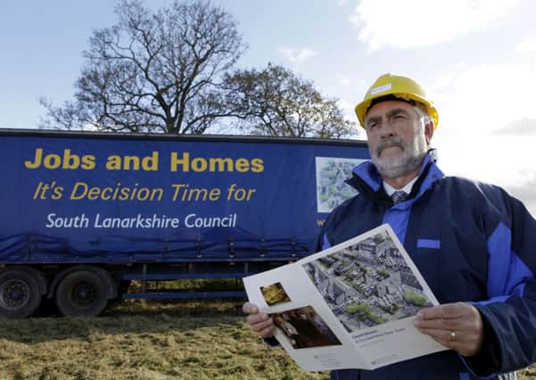 Banner...project manager Bob Laverty at the sign which is part of a 'charm offensive' to convince South Lanarkshire Council to grant Owenstown (Contributed Pic)