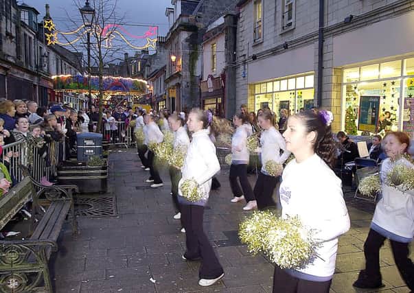 LIGHTING UP: Crowds line Kilsyth Main Streeet to enjoy the entertainment at the towns Christmas lights switch on in November 2003. Pic ref. 5765d