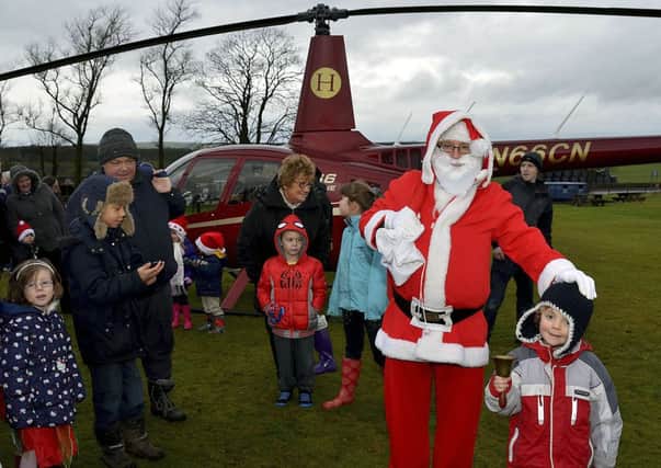 High flier...Santa Claus used a helicopter rather than his traditional sleigh when he stopped off in Carnwath (Pic by Rodger Price)