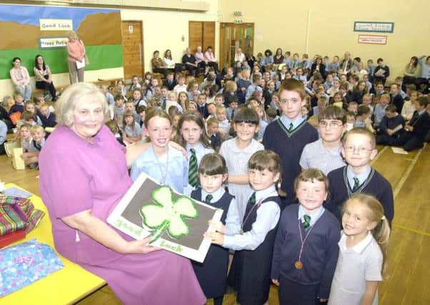 SAYING FAREWELL: Youngsters of St Lucys Primary School in Abronhill say farewell to their headteacher Mary Ann Smith on her retiral in 2004.
