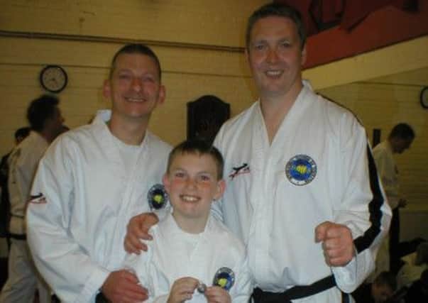 Champions...Alan Alexander and his son Lewis (14) who have both won black belts, with TKD instructor David Condie (right)