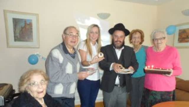 Residents Lily Wise and Morris Shapiro celebrate with Rabbi Jacobs and Newark Care staff and volunteers.