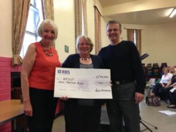 SFCCF founder Phyllis (left) and David Devlin accept a cheque from Sounds International treasurer Liz Yates
