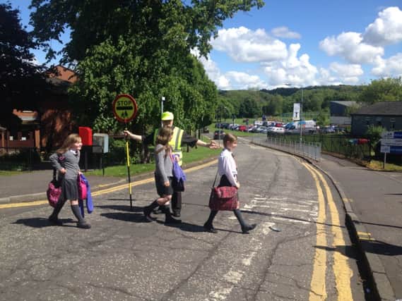 Lollipop man Robert Mathieson escorts Lucy (7) and Beth (10) Cunningham and Lucy Elliot (10) at the new manned crossing.