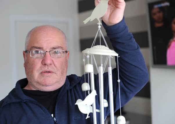 Robert Russell with the offending wind chimes.