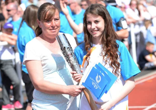 Handover...the Queen's Baton changes hands as it prepares to leave the John Cumming Stadium on Sunday, June 22, 2014 and carry on to Law (Pics by Alan Watson)