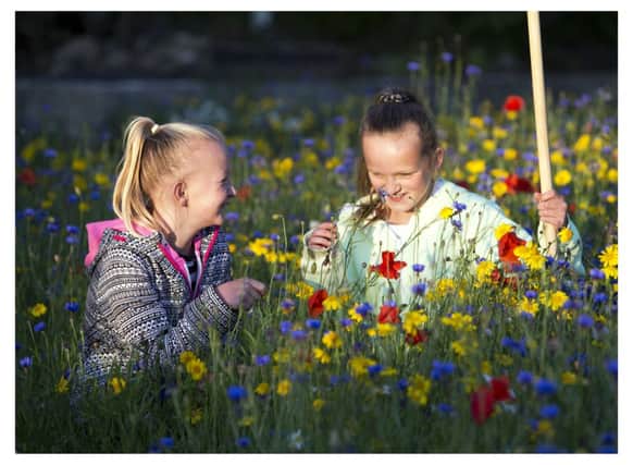 Dunterlie Youth Group members Amy Grey (12) and Leah Henderson (11) enjoy the communitys new wildflower garden