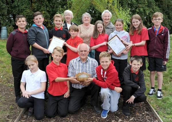 Blooming great...Lanark in Bloom members with chairman Ernest Romer centre front with trophy and some of his young gardeners at Lanark Primary School. (

Pic by Alan Watson)