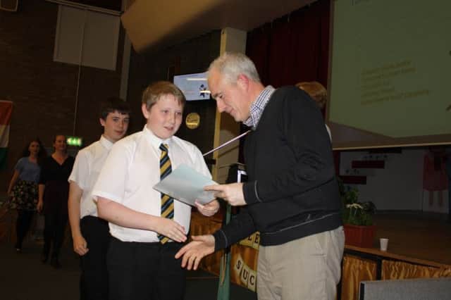 Pastor Don Palmer, of the Glasgow South East Foodbank, presents awards and receives a welcome donation from Hillpark pupils.