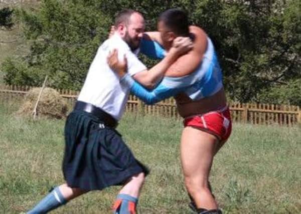 Wrestler...Robert MacDonald (kilted) grapples with Mongolian wrestler