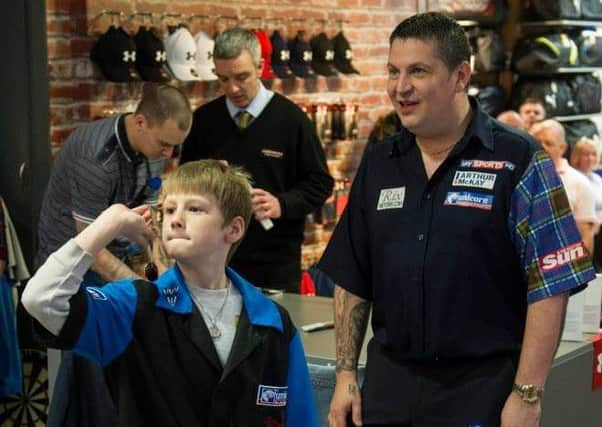 Worried world champ...Gary Anderson looks concerned as Adrian lines up his attempt at a winning double top