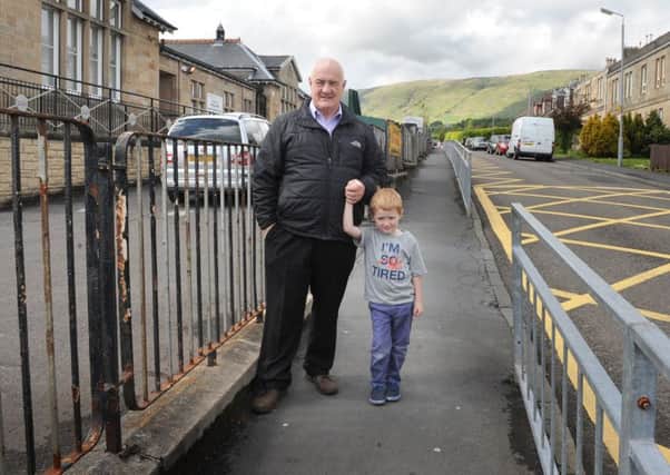 5-06-2015 Picture Jamie Forbes. Milton of Campsie. David McHugh with grandson Gregor highlighting problems of dog mess on pavement outside Craighead PS.