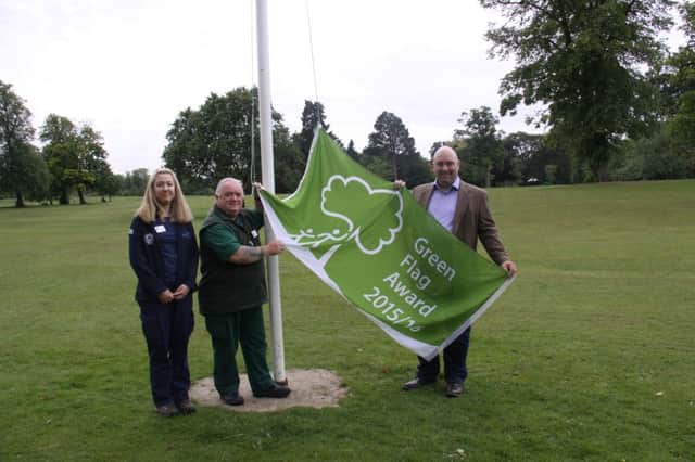 Activity ranger Katy Green and senior park ranger Garry Nixon raise the new flag with help from councillor Waters