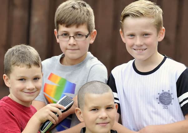 Picture 26/08/15 Emma Mitchell.
Matthew Lowrie (11) and pals who shaved his head for cancer research. Mathew with brother Sean and his friends Paul MCmullan and Lachlan Frame.