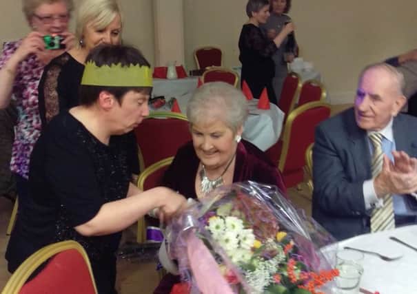 Doreen McFarlane (87), co-founder of the Trust is presented with flowers by tenant Marcia McNish.