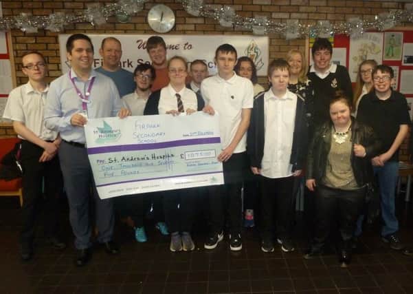 School captains Mary Sweeney and Ryan Murphy present the cheque to the hospices Andy Flynn, flanked by Firpark pupils and staff.
