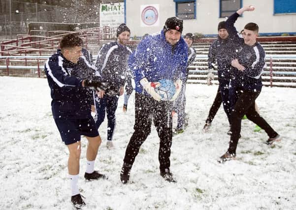Cumbernauld United players have some fun as they train in the snow .... but a series of call-offs is no laughing matter.