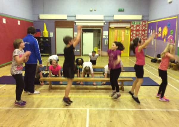 Pupils try star jumps, under the guidance of Commonwealth Games gymnastics silver medallist Liam Davie at Tinto Primary