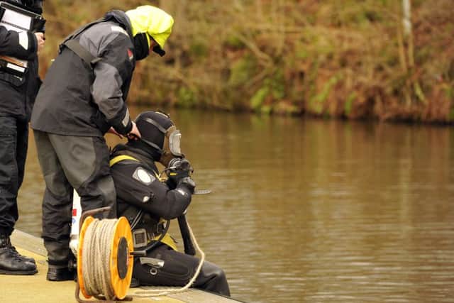 Police divers search the canal