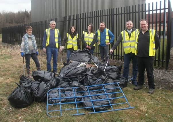 SNP members show off the bags of rubbish and other debris they collected