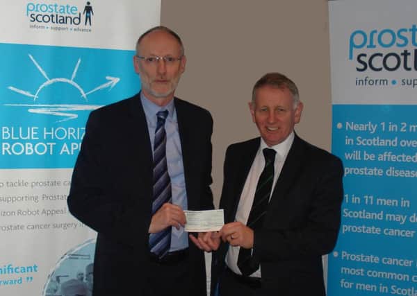 Provincial Grand Master, Bro Tom Davidson, (right) hands over the Â£1,400 cheque for Blue Horizon to Adam Gaines of Prostate Scotland.