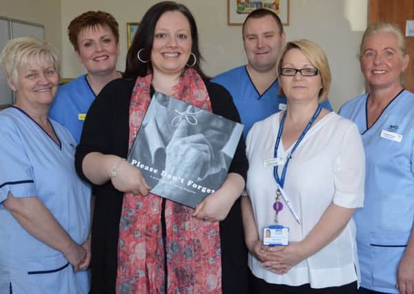 Zaria Sleith (third, left) returns to ward six to show (l-r) care support worker Moira Burgon, staff nurse Morag Weir, staff nurse Kevin Scullion, coordinator for carers Lorraine Finnigan and care support worker Margaret Murphy a copy of Please Don't Forget