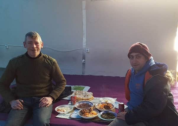 Stuart Martin from Milngavie (left) having a meal with Fuad an English volunteer.