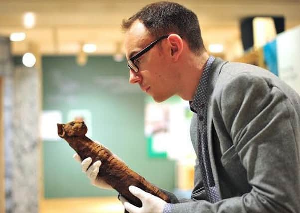 Dr Campbell Price with an animal mummy