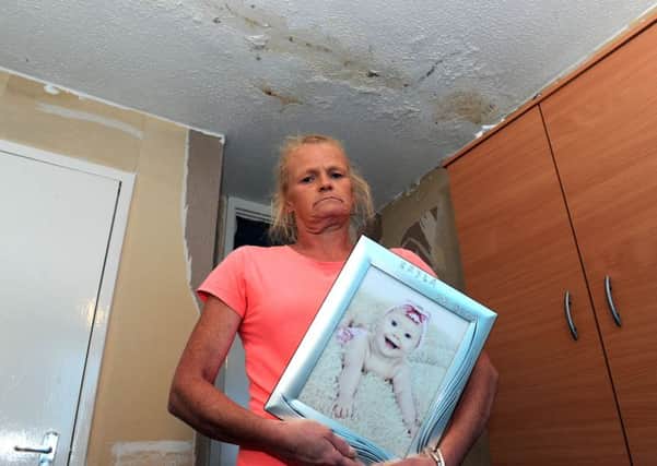 Wendy Anderson clutches a picture of her granddaughter Kayla who she wants to be able to come for visits again, but needs her flat fixed first.