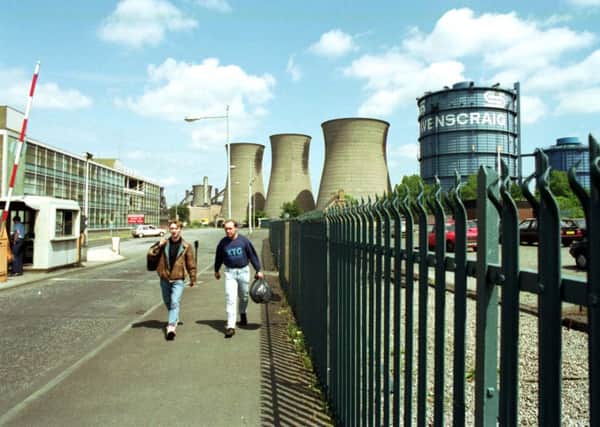 Two men walk through the gates of Ravenscraig steelworks after the last shift before the plant closed in June 1992.