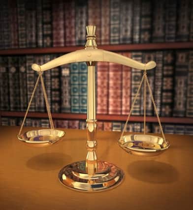 Brass Scales of Justice on a desk showing Depth-of-field books behind in the background