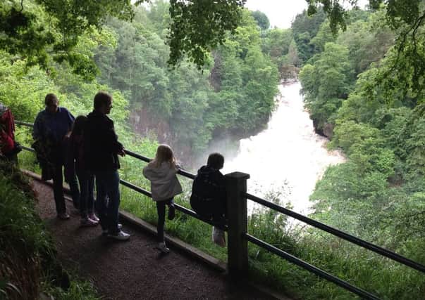 Visitors admire the awesome spectacle of Corra Linn
, one of the Falls of Clyde