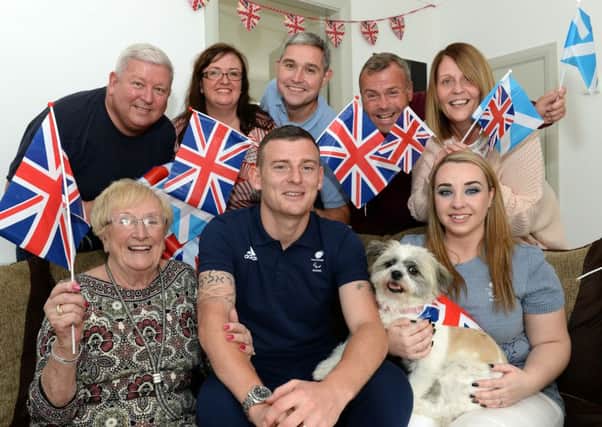 Jonathan (front) pictured next to wife Lisa (front right), gran Anne and dog Poppy enjoyed a Paralympic party with family and friends