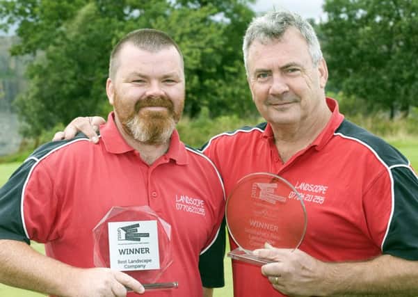 Landscope founder Brian Lallaway (left) with foreman Tony Williams  and the national Best Landscaping Company awards the company has won in 2015 and 2016.